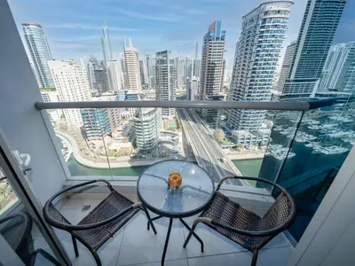 a table and chairs on a balcony with a view of a city at Spacious 3 Bed Marina Haven with Waterfront Views in Dubai