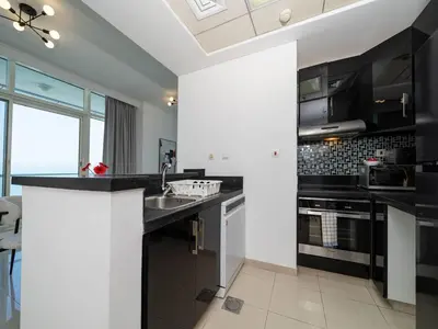 a kitchen with black and white counters and a sink at Elegant 1-Bedroom Retreat with Marina Views in Dubai