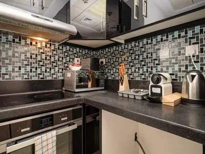 a kitchen with black and white tiles on the wall at Elegant 1-Bedroom Retreat with Marina Views in Dubai