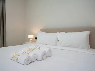 a white bed with three rolls of towels on it at Luxurious 2 Bed Waterfront Living at Marina Quays in Dubai