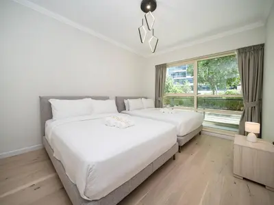 two beds in a room with a window at Luxurious 2 Bed Waterfront Living at Marina Quays in Dubai