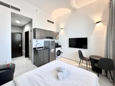 a bedroom with a bed and a kitchen with a tv at Al Manara Classic Deluxe Sheikh Zayed Studio in Dubai