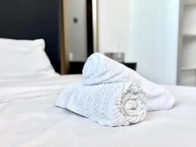 a white towel sitting on top of a bed at Al Manara Classic Deluxe Sheikh Zayed Studio in Dubai