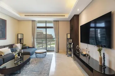a living room with a couch and a tv at Best View Luxury 2BDR Palm Jumeirah, Beach & Pool in Dubai