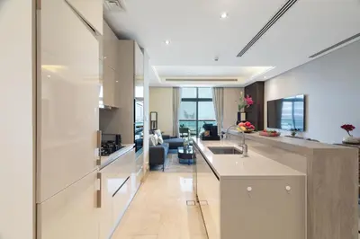 a kitchen and living room with a glass wall at Best View Luxury 2BDR Palm Jumeirah, Beach & Pool in Dubai