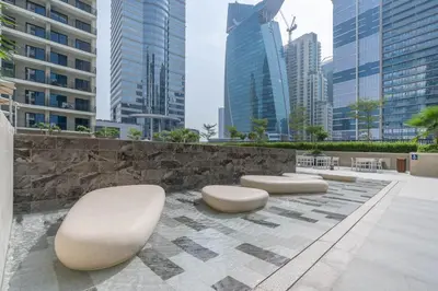 a row of white benches in a city with tall buildings at Perfect Location-For Work or Leisure in Dubai