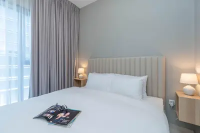 a bedroom with a white bed with a magazine on it at Perfect Location-For Work or Leisure in Dubai