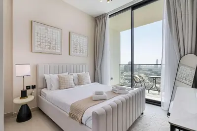 a white bedroom with a bed and a large window at PVH - Elegant 1BR in Binghatti House in Dubai