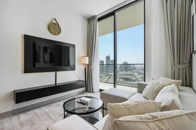 a living room with a white couch and a tv at PVH - Elegant 1BR in Binghatti House in Dubai