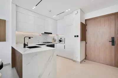 a white kitchen with a sink and a counter at PVH - Elegant 1BR in Binghatti House in Dubai