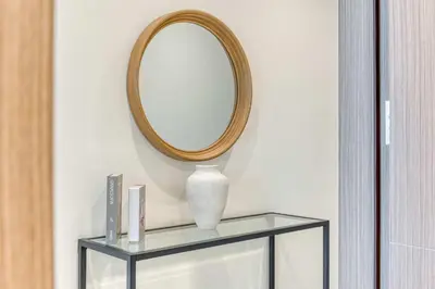 a mirror on a wall next to a glass shelf at PVH - Lavish 1BR in Peninsula Five in Dubai