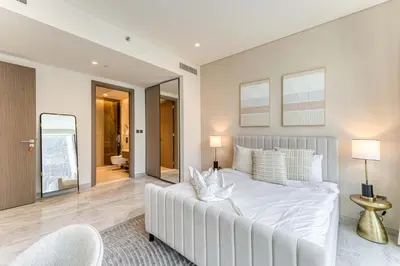 a bedroom with a large white bed with two lamps at PVH - Lavish 1BR in Peninsula Five in Dubai