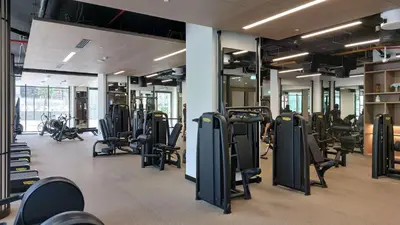 a gym with a bunch of chairs and machines at PVH - Lavish 1BR in Peninsula Five in Dubai