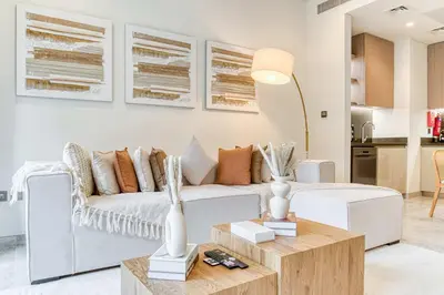 a living room with a white couch and a table at PVH - Lavish 1BR in Peninsula Five in Dubai