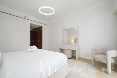 a white bedroom with a white bed and a desk at LUX The Al Seef Marina Suite 2 in Dubai