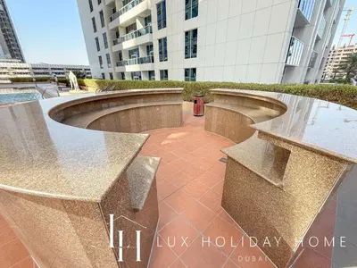 a row of stone benches in front of a building at LUX The Al Seef Marina Suite 2 in Dubai