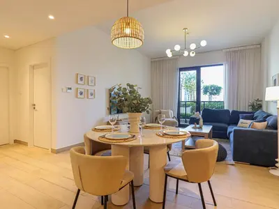 a dining room and living room with a table and chairs at HiGuests - Modern Escape in Jumeirah Bliss in Dubai