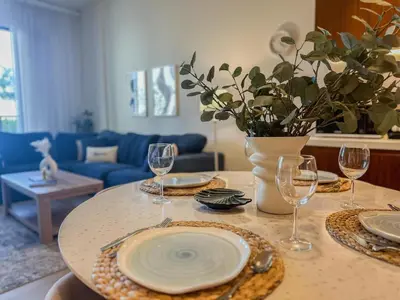 a table with plates and wine glasses on it at HiGuests - Modern Escape in Jumeirah Bliss in Dubai