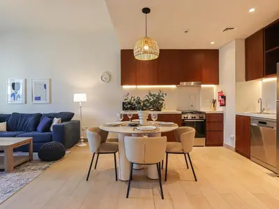 a kitchen and living room with a table and chairs at HiGuests - Modern Escape in Jumeirah Bliss in Dubai
