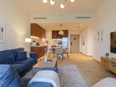 a living room with a blue couch and a table at HiGuests - Modern Escape in Jumeirah Bliss in Dubai