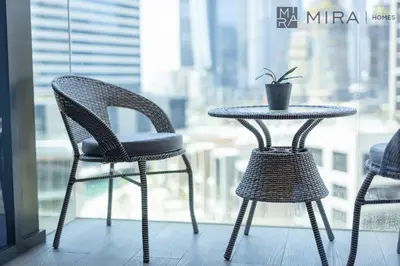 a table and chairs in front of a window at Stylish 1BR in Peninsula Five Views & Pool in Dubai