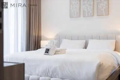 a bedroom with a white bed with a sign on it at Stylish 1BR in Peninsula Five Views & Pool in Dubai