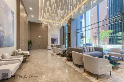 a lobby with chairs and a chandelier in a building at Stylish 1BR in Peninsula Five Views & Pool in Dubai