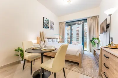 a bedroom with a bed and a table and chairs at Studio with Pool and Community View, Near Soho Garden DXB and Meydan Golf Club, Azizi Riviera 43, Al Merkadh by Deluxe Holiday Homes in Dubai