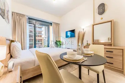 a bedroom with a bed and a table and chairs at Studio with Pool and Community View, Near Soho Garden DXB and Meydan Golf Club, Azizi Riviera 43, Al Merkadh by Deluxe Holiday Homes in Dubai