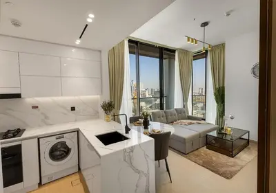 a kitchen and living room with a couch at Brand New Luxurious 1 BR with Garden, Gym, Pool and Open View in Dubai