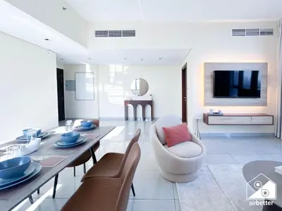 a living room with a table and chairs and a television at Cozy One-Bedroom in O2 Tower, JVC in Dubai