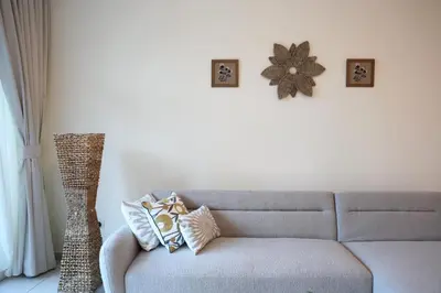 a living room with a couch and a flower on the wall at Nivis find- Luxury & Spacious 1 BHK 10 mins away from Dubai mall in Dubai