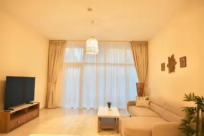 a living room with a couch and a television at Nivis find- Luxury & Spacious 1 BHK 10 mins away from Dubai mall in Dubai