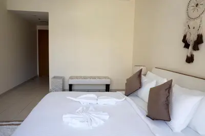 a white bed with white sheets and pillows at Nivis find- Luxury & Spacious 1 BHK 10 mins away from Dubai mall in Dubai