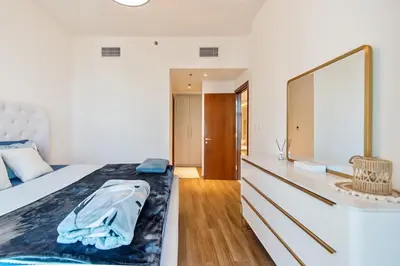 a bedroom with a bed and a dresser with a mirror at DreamShoma-1BR Stunning Canal View in Dubai