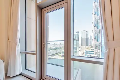 a window with a view of a city at DreamShoma-1BR Stunning Canal View in Dubai