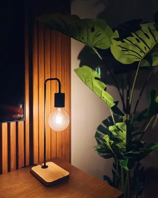 a lamp sitting on a table next to a plant at Dubai Marina Modern 1 Bedroom Apartment - steps to tram & Marina Walk in Dubai
