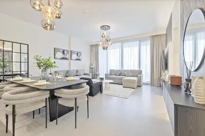 a dining room and living room with a table and chairs at Mahogany 8 - 4BR 14PAX - Burj Khalifa View Central in Dubai