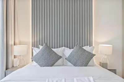 a bedroom with a white bed with pillows on it at Mahogany 8 - 4BR 14PAX - Burj Khalifa View Central in Dubai