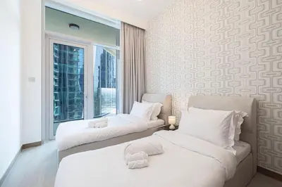 a hotel room with two beds and a window at Mahogany 3 - 2BR 6 Guests - Pool & Prime Location in Dubai