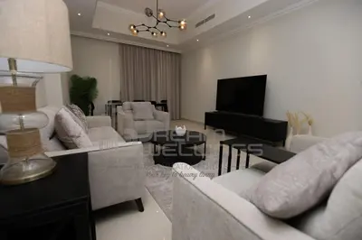 a living room with white furniture and a television at Downtown Dunya Tower in Dubai