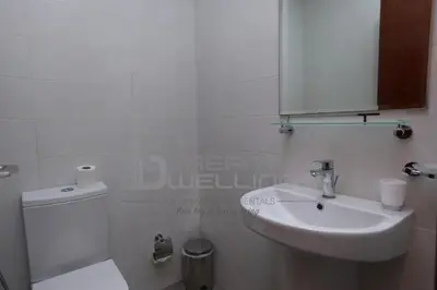 a bathroom with a sink and a toilet and a mirror at Downtown Dunya Tower in Dubai