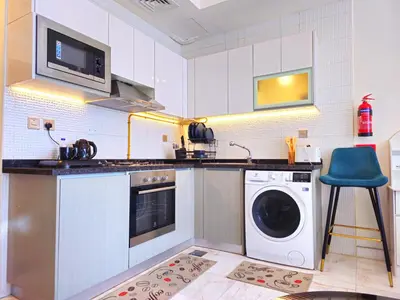 a kitchen with a washer and a washing machine at Burj Khalifa view studio apartment in Business bay, Downtown in Dubai