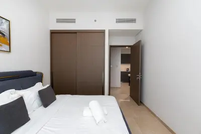 a bedroom with a bed with white sheets at Elegant Downtown Retreat in Dubai