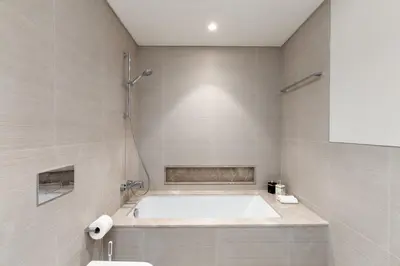 a bathroom with a bath tub and a sink at Elegant Downtown Retreat in Dubai