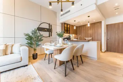 a kitchen and living room with a table and chairs at Brand New Building with Resort-style Amenities, Hamilton House, JVC By Deluxe Holiday Homes in Dubai