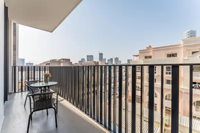 a balcony with a table and a view of the city at Brand New Building with Resort-style Amenities, Hamilton House, JVC By Deluxe Holiday Homes in Dubai
