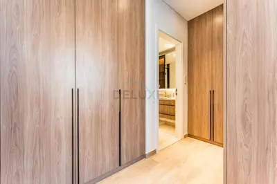 a room with wooden cabinets and a hallway at Brand New Building with Resort-style Amenities, Hamilton House, JVC By Deluxe Holiday Homes in Dubai