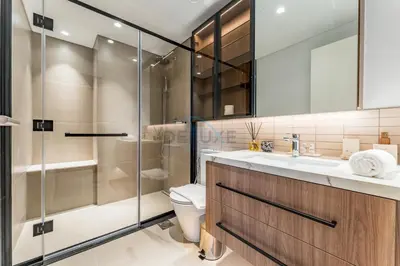 a bathroom with a toilet and a glass shower at Brand New Building with Resort-style Amenities, Hamilton House, JVC By Deluxe Holiday Homes in Dubai