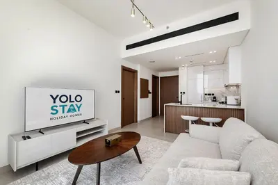a living room with a couch and a table at Cozy 1BR apartment in Binghatti Venus JVC in Dubai